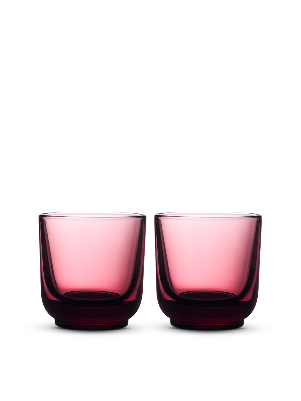 Two garnet coloured glass tumblers on a white background
