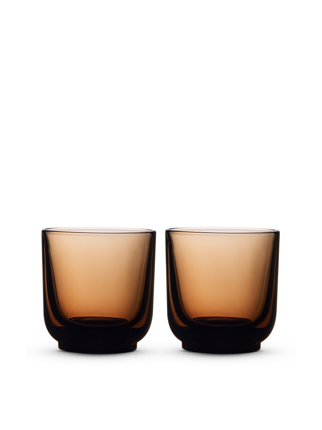 Two amber-colored glass tumblers on a white background