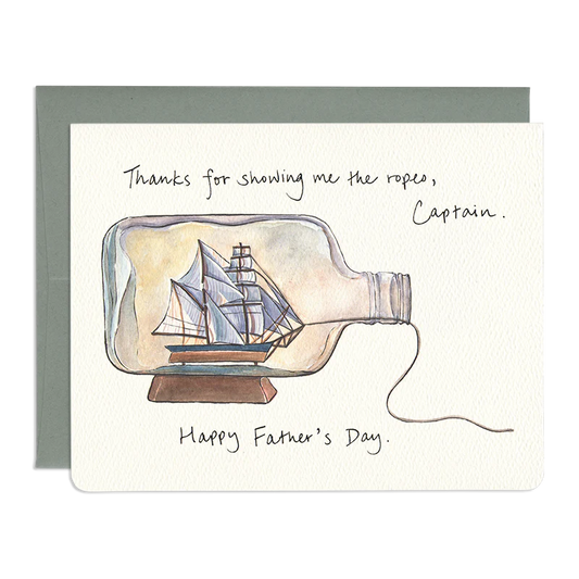 A card with sailing ship in a bottle on a white background with the words: "Thanks Father's Day" written on it. 