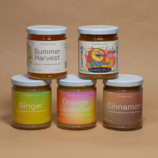 Five jars of Sonobee Hills honey with colourful labels on a brown background
