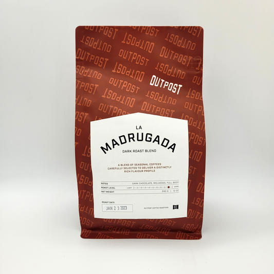 A packaged bag of Outpost Coffee Roasters' La Madrugada dark roast blend coffee, with branding and product information displayed on the front.