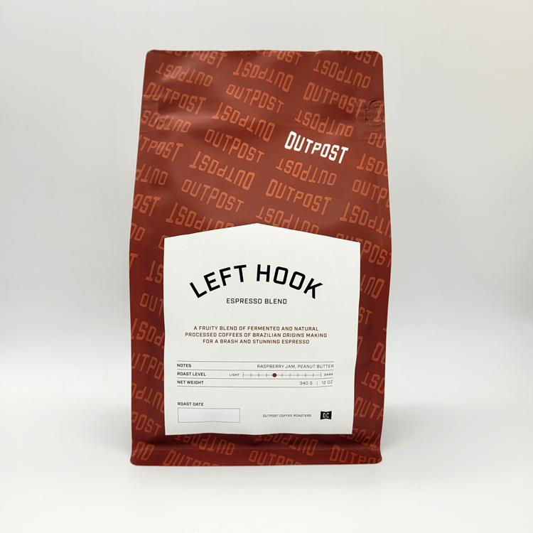 A package of Outpost Left Hook Espresso blend coffee, with a white label on a brown background featuring product information.